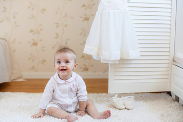 Fototapeta premium portrait of pretty smiling baby girl sitting on the floor