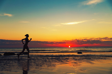 Fototapeta na wymiar Silhouette of female runing along the sea coast