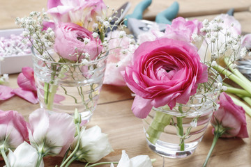 Florist workplace: incomplete tiny bouquets in glass vases. Step