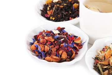 Cup of tea with aromatic dry tea in bowls isolated on white