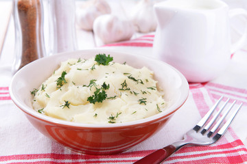Delicious mashed potatoes with greens in bowl on table close-up
