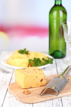 Composition with tasty spaghetti, grater, cheese, wine bottle
