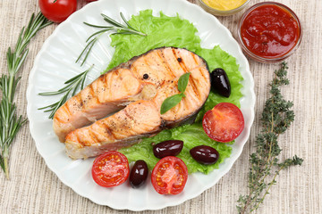 Tasty grilled salmon with vegetables, close up