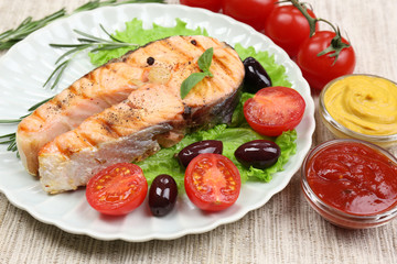 Tasty grilled salmon with vegetables, close up