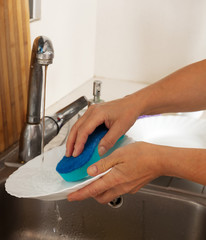 Woman's hands washing plates