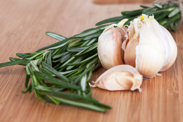 Rosemary and garlic on a wooden chopping board