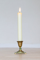 Burning candle on wooden table