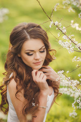 Naklejka premium Portrait of a young brunette in the spring garden
