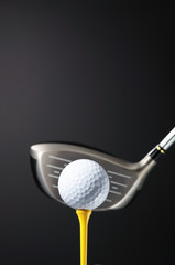 Golf club and ball on tee.
