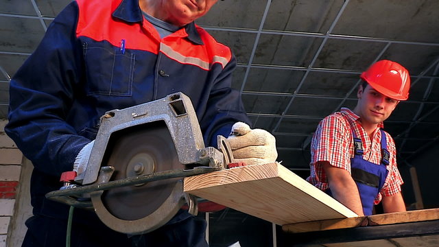 Happy group people  builder with circular saw.