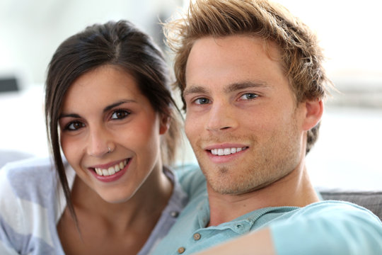 Smiling young couple relaxing in sofa at home