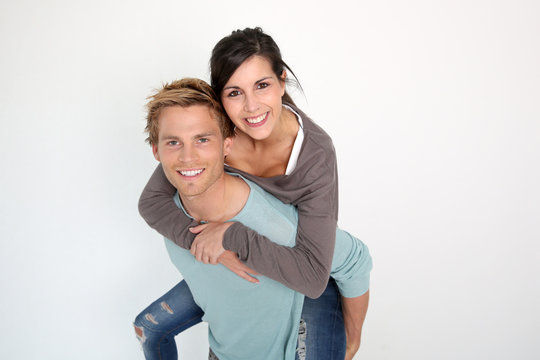 Young man giving piggyback ride to girlfriend
