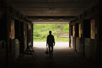 An organic farm in the Catskills. A man walking through a stable.