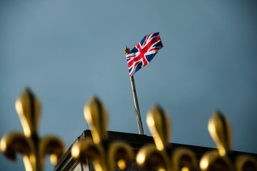 golden fence of buckingham palace with british flag
