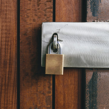 Close up of a wooden doorway, with a padlock. 