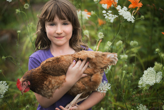 Portrait of girl holding  hen