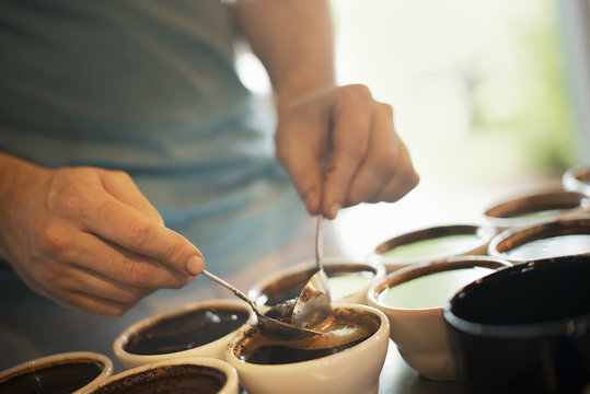The sampling procedure in a coffee processing shed, where staff make coffee in small pots and sample the taste to test the blend. 