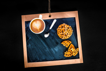 coffee latte with heart and oatcakes on chalkboard, top view