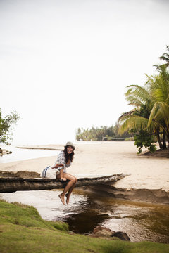 A young woman on a wooden bridge over a small creek on Samana Peninsula in the Dominican Republic.