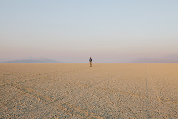 The figure of a man in the empty desert landscape of Black Rock desert, Nevada. 