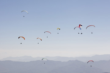 Parapentistes dans la brume matinale