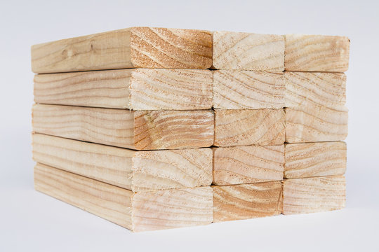 Stack of sawn prepared timber, spruce wood planks or studs, for use. Treated wood in traditional 2 by 4 measured cut shapes. Cut ends.