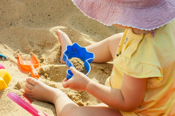 Little girl playing with toys in the sand