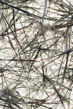 A pile of long thin shredded pieces of printed newspapers.