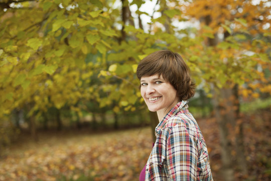 A woman in woodland on an autumn day. 