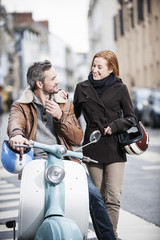 handsome couple riding a trendy scooter