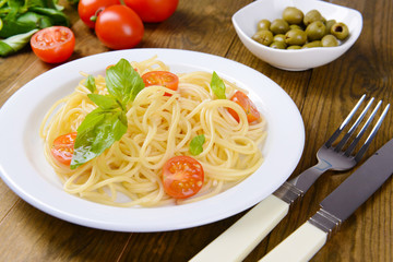 Delicious spaghetti with tomatoes on plate on table close-up