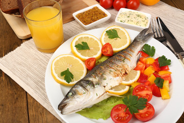 Delicious grilled fish on plate on table close-up