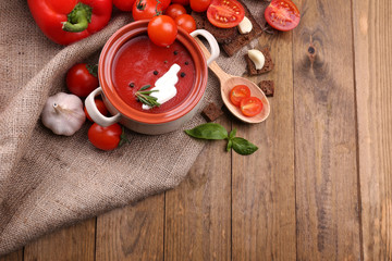 Tasty tomato soup and vegetables on wooden table