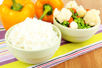 Cooked rice with vegetables on wooden table close up