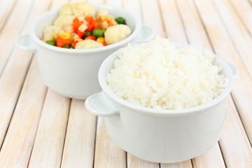 Cooked rice with vegetables on wooden table close up
