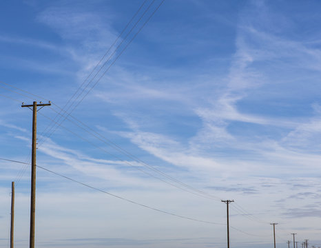 Telephone poles and power lines in a line across the landscape at Belridge, California.