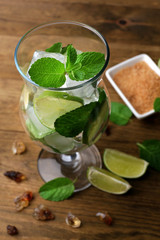 Ingredients for lemonade in glass, on wooden table