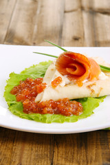 Pancake with salmon, red caviar and mayo, green onion,