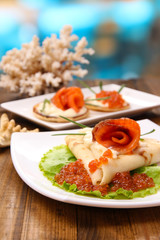Pancakes with red caviar, salmon and mayo, green onion,