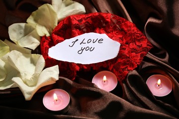 Beautiful red rose petals with candles and greeting card, close