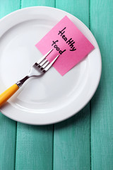 Note paper with message  attached to fork,