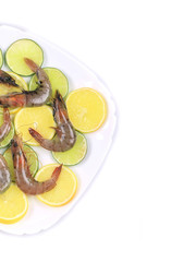 Raw shrimps on plate with lemon and lime.