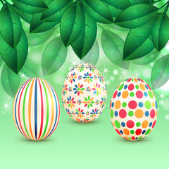 Easter eggs with colorful patterns on a background of spring fol