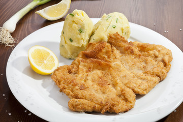 Vienna schnitzel with mashed potatoes and baby onion