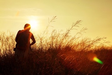 trekker walking on grass field when sunset