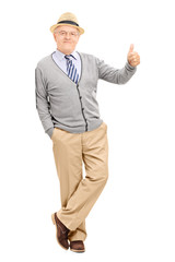 Man leaning against a wall and giving thumb up