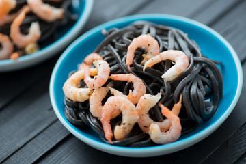 Black tagliatelle with shrimps, horizontal shot, close-up