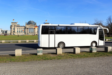 Weisser Reisebus vor Berliner Wahrzeichen Reichstag