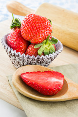 Strawberry on wood spoon and paper cup