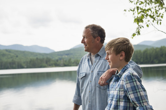 Father and son standing by lake